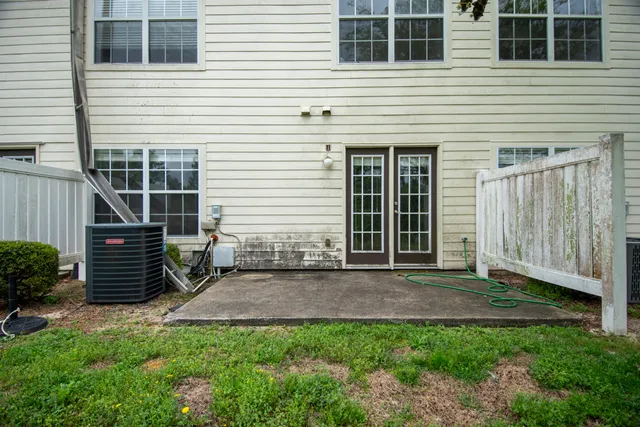 a view of backyard with seating space and wooden fence