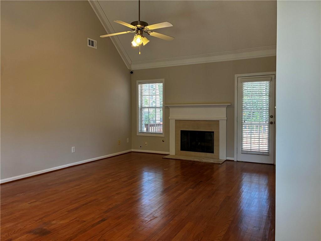337 Madison Avenue Hampton, GA 30228 - Photo 7 of 32 an empty room with wooden floor fireplace fan and windows