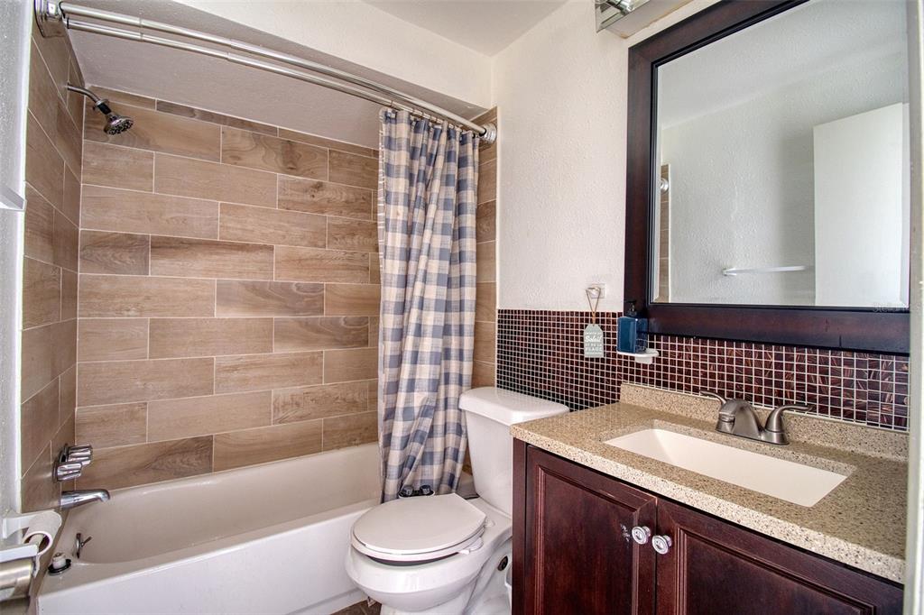 4242 Redcliff Place, Unit C New Port Richey, FL 34652 - Photo 11 of 15 a bathroom with a granite countertop sink toilet and shower