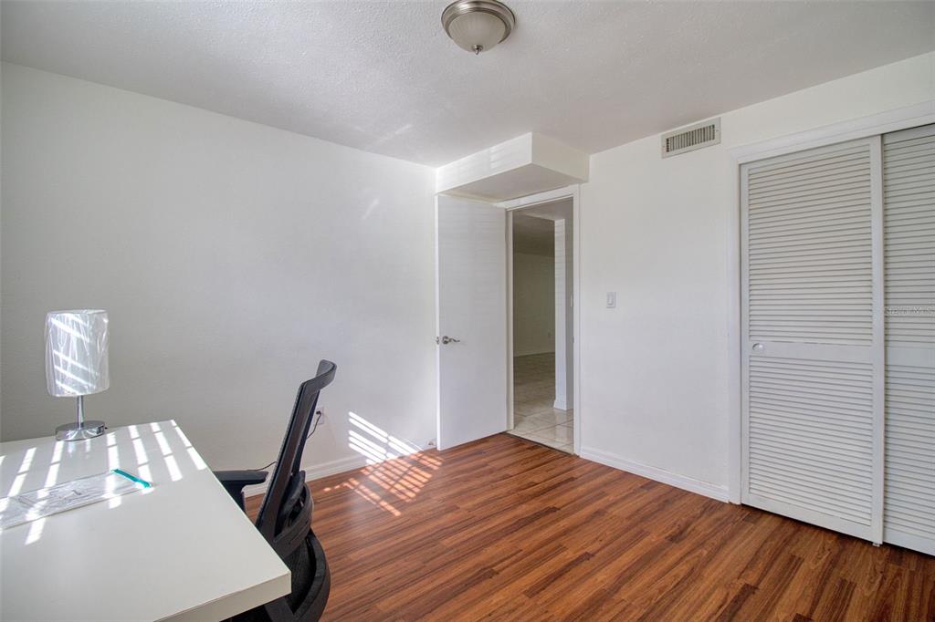 4242 Redcliff Place, Unit C New Port Richey, FL 34652 - Photo 10 of 15 a view of a bedroom with wooden floor