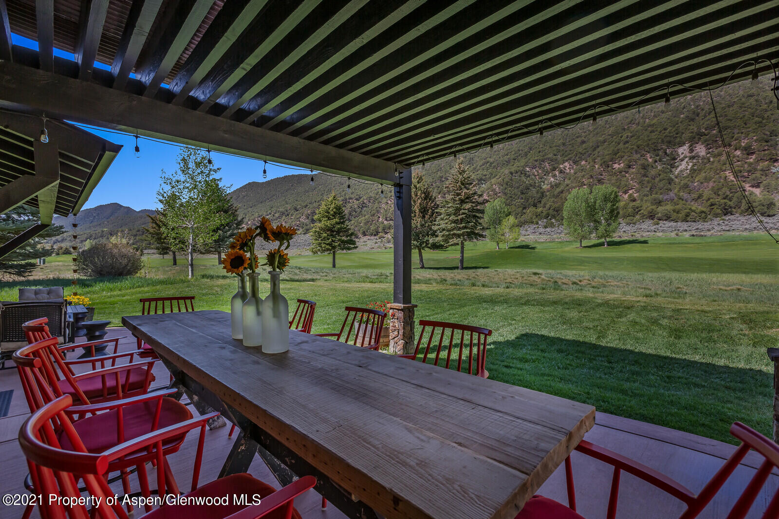 245 Saddleback Road Carbondale, CO 81623 - Photo 18 of 19 a view of a patio with table and chairs with wooden floor and fence