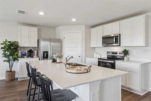 a kitchen with a table chairs stove and cabinets