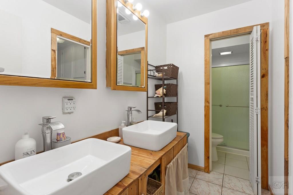 4444 18th Street Bacliff, TX 77518 - Photo 10 of 13 a bathroom with a sink vanity and a mirror