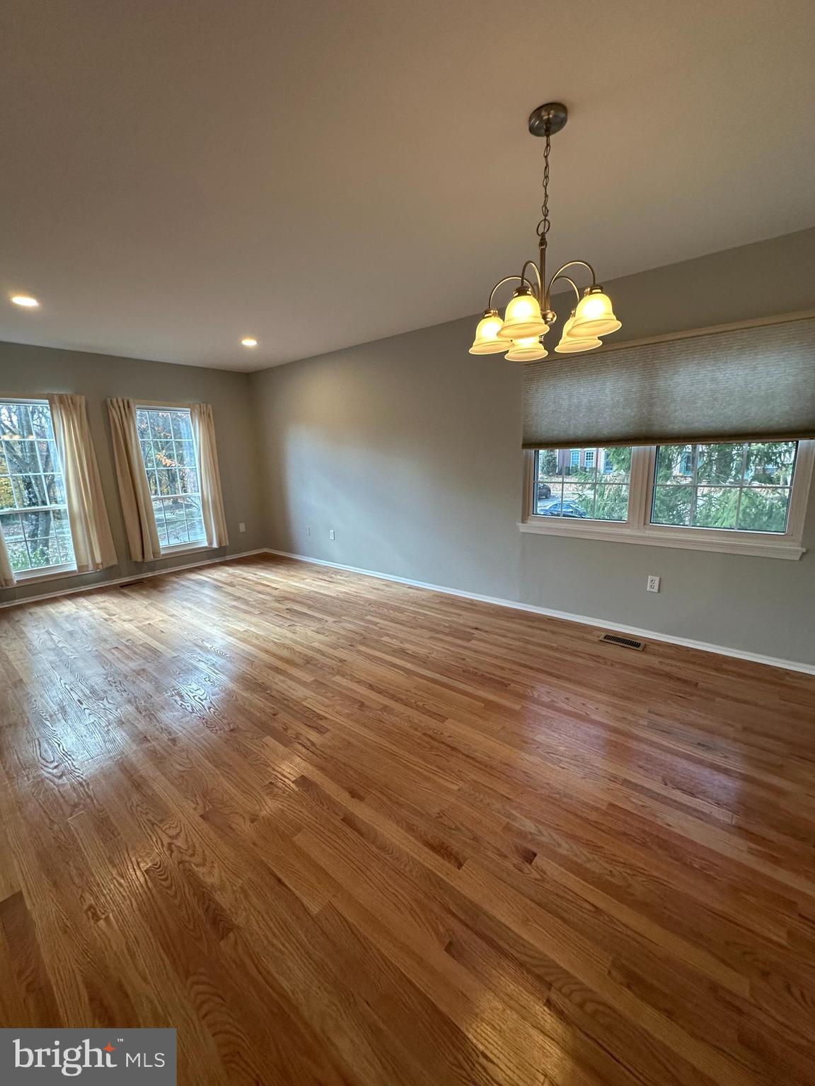 4031 Forest Valley Road Baltimore, MD 21234 - Photo 4 of 19 a view of a livingroom with a chandelier fan a fireplace and wooden floor