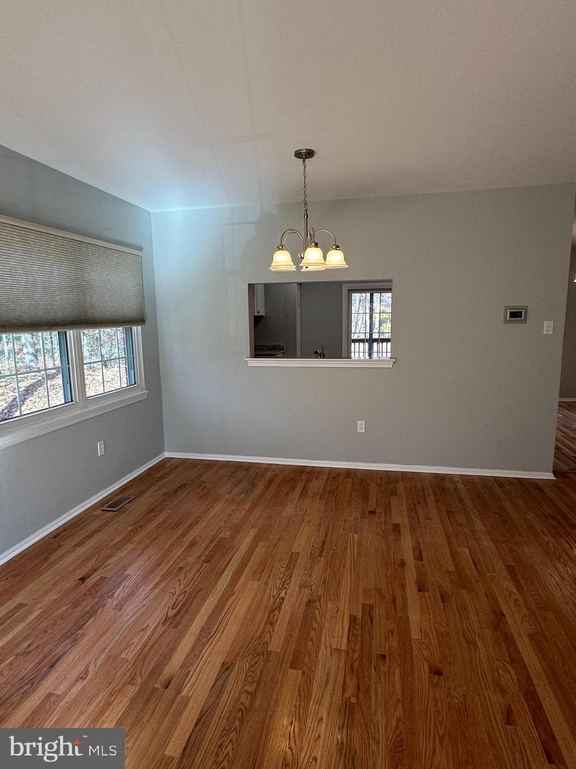 4031 Forest Valley Road Baltimore, MD 21234 - Photo 5 of 19 a view of an empty room with wooden floor and windows