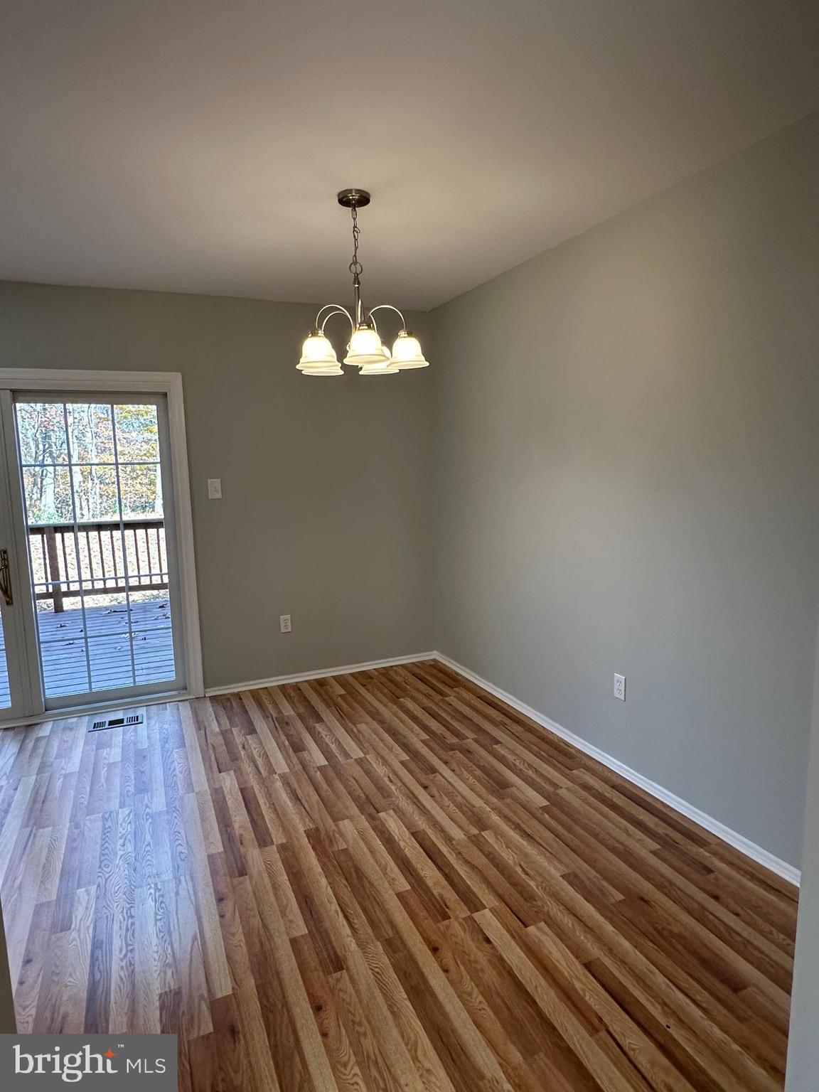 4031 Forest Valley Road Baltimore, MD 21234 - Photo 7 of 19 a view of an empty room with wooden floor and a window