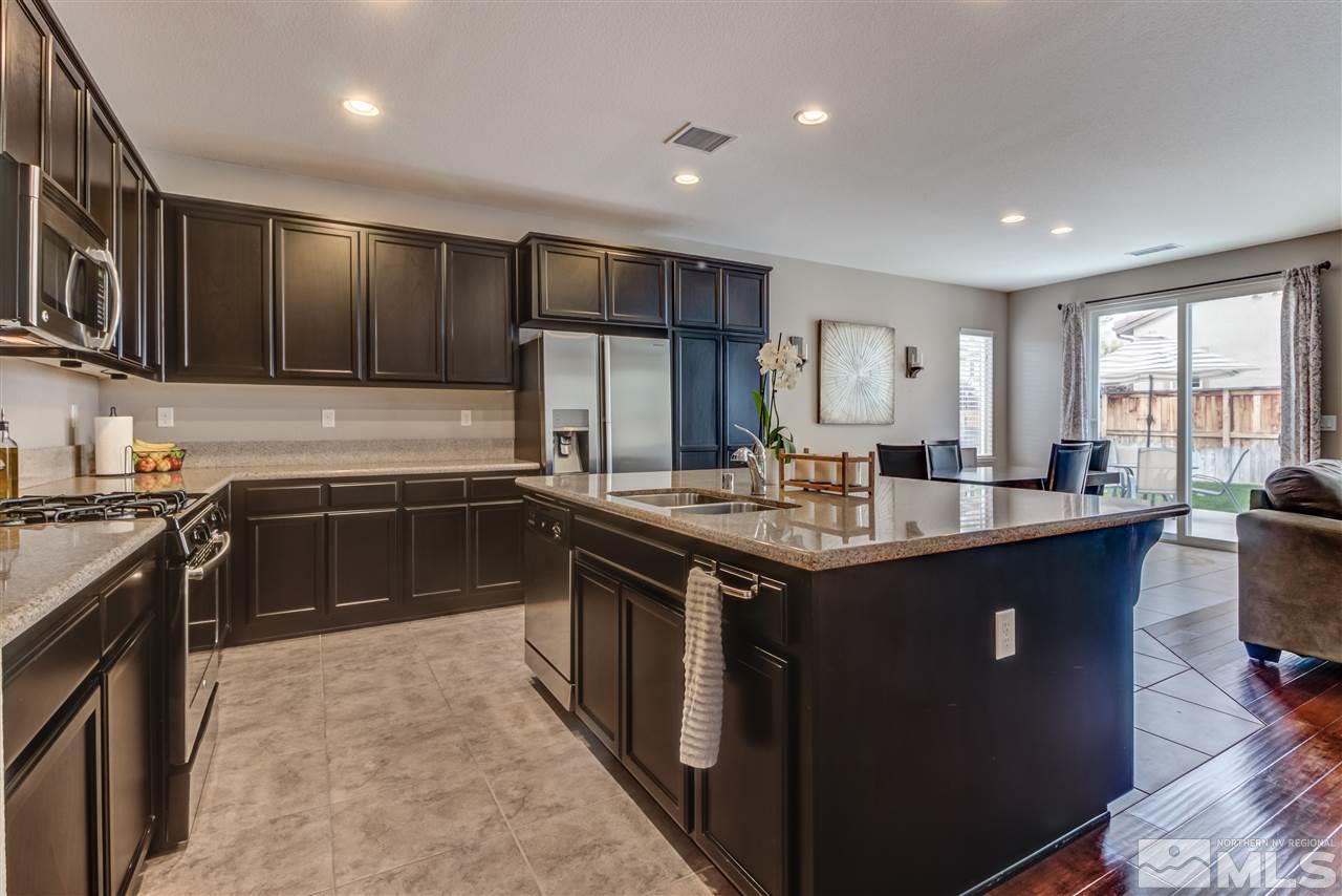 9340 Mill Iron Road Reno, NV 89521 - Photo 4 of 25 a kitchen with stainless steel appliances granite countertop a sink stove and refrigerator
