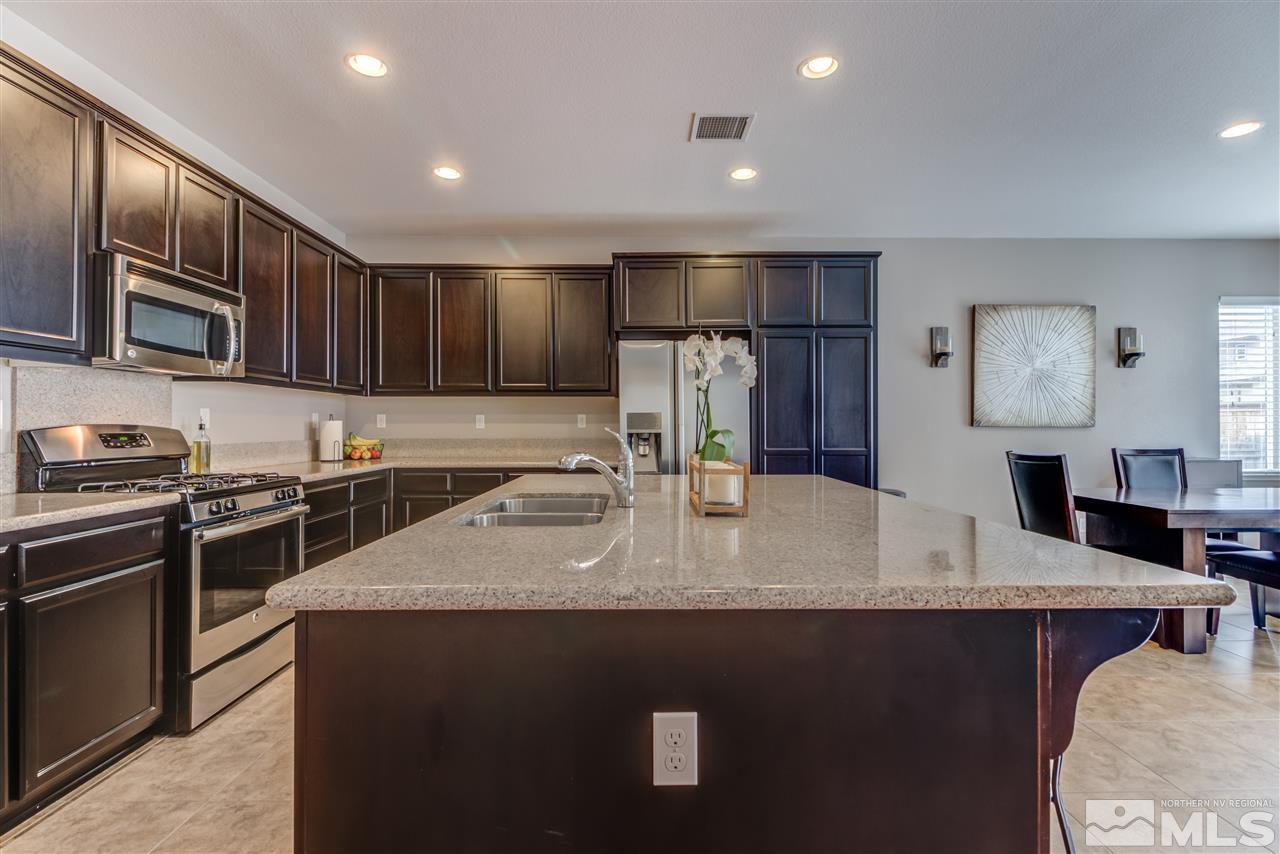 9340 Mill Iron Road Reno, NV 89521 - Photo 6 of 25 a kitchen with stainless steel appliances granite countertop a sink a stove top oven a refrigerator and dishwasher