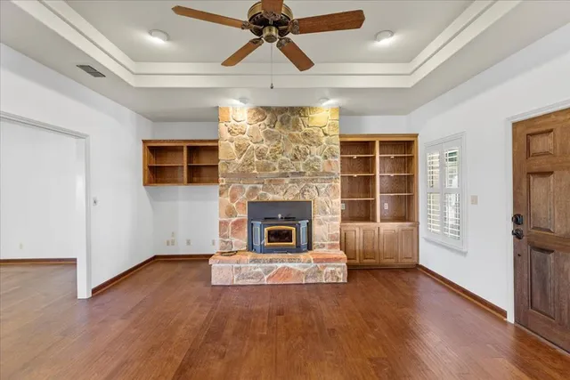 a living room with a fireplace and wooden floor