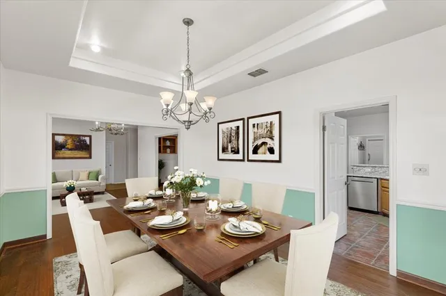 a view of a dining room with furniture a chandelier and wooden floor