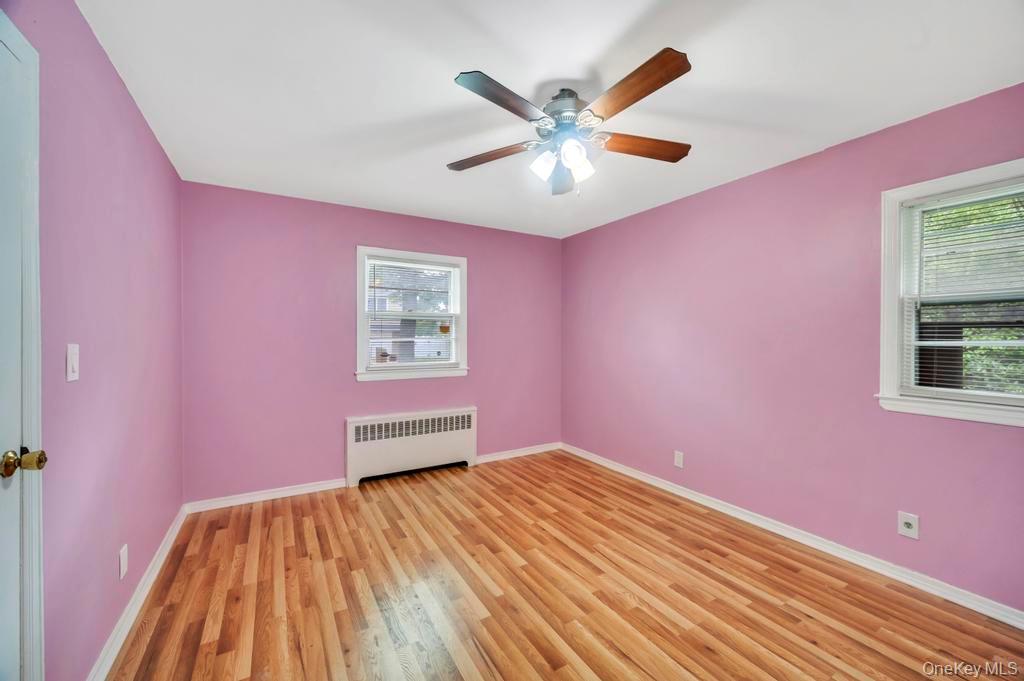 51 Stevenson Road Hewlett, NY 11557 - Photo 13 of 21 Spare room with radiator heating unit, light wood-style floors, and ceiling fan