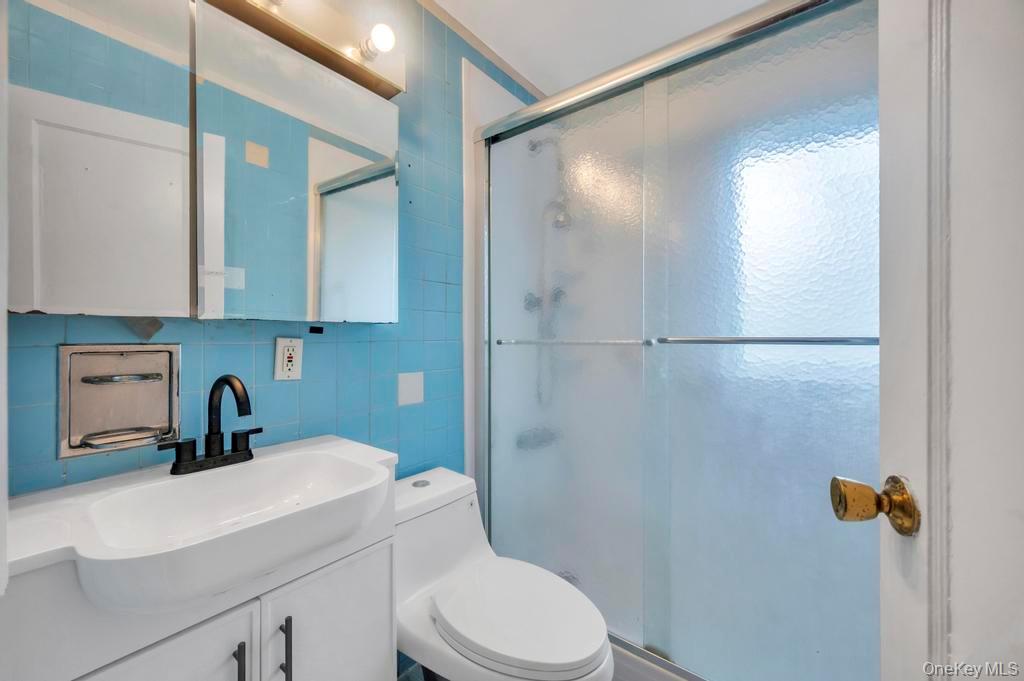 51 Stevenson Road Hewlett, NY 11557 - Photo 15 of 21 Full bath featuring vanity, a stall shower, tile walls, and tasteful backsplash