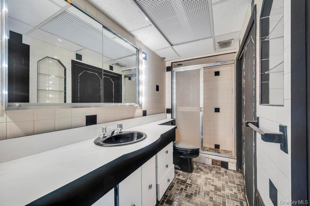 51 Stevenson Road Hewlett, NY 11557 - Photo 16 of 21 Full bath with a stall shower, tile walls, vanity, a drop ceiling, and tasteful backsplash