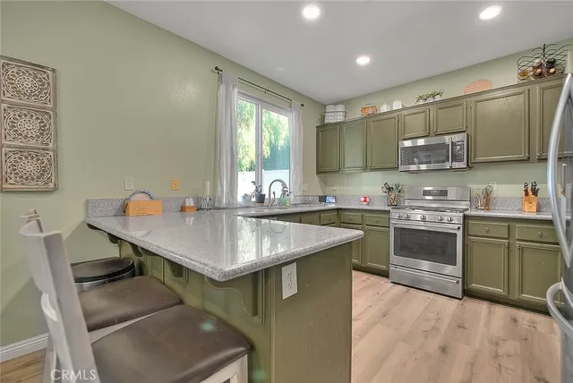 a kitchen with stainless steel appliances granite countertop a sink dishwasher stove refrigerator and cabinets