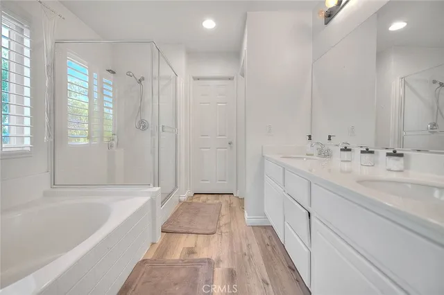 a spacious bathroom with a double vanity sink a mirror and a shower