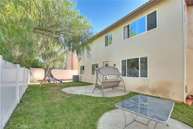 a view of a chair and table in backyard of the house