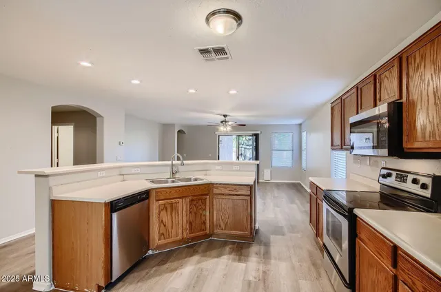 a large kitchen with stainless steel appliances granite countertop a lot of counter space and wooden floor