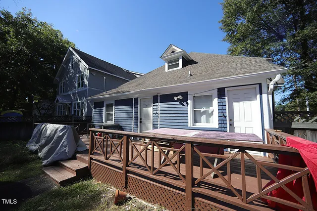 a view of a house with wooden deck and furniture