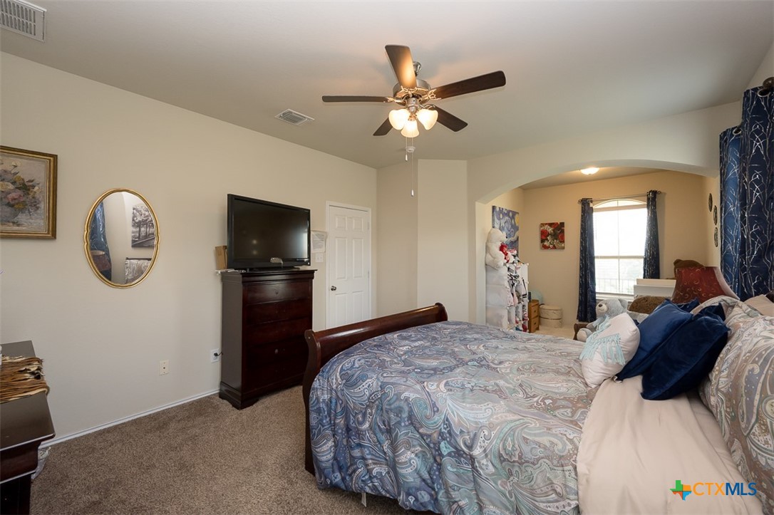 2511 Pintail Loop Copperas Cove, TX 76522 - Photo 15 of 26 a bedroom with a bed and a chandelier