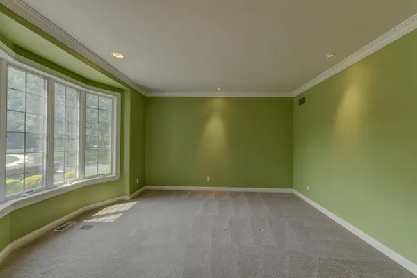 a view of an empty room with a fireplace and a window