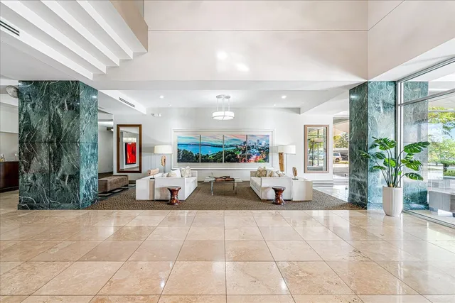 a living room with furniture a floor to ceiling window and potted plants