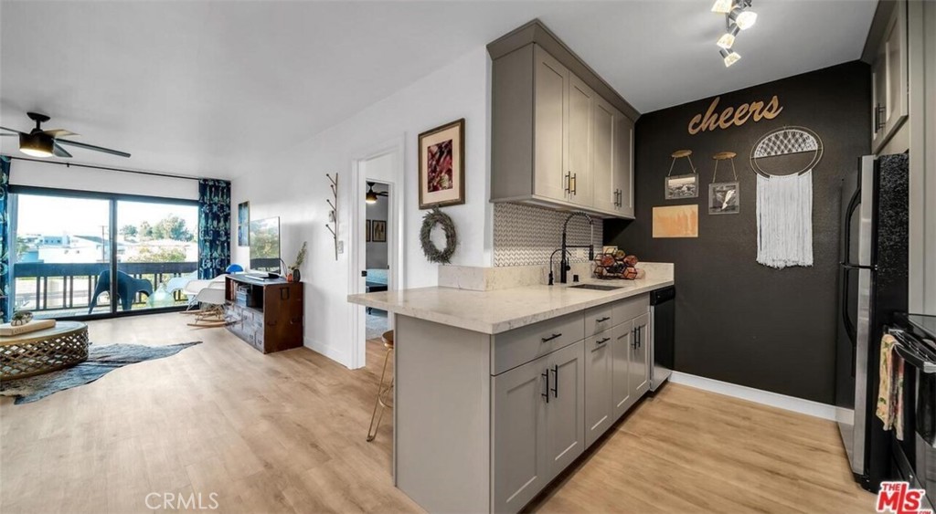 7742 Redlands Street, Unit H3025 Playa del Rey, CA 90293 - Photo 2 of 14 a large kitchen with stainless steel appliances granite countertop a lot of counter space and wooden floor