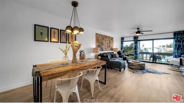 a living room with furniture dining table a large window and a chandelier
