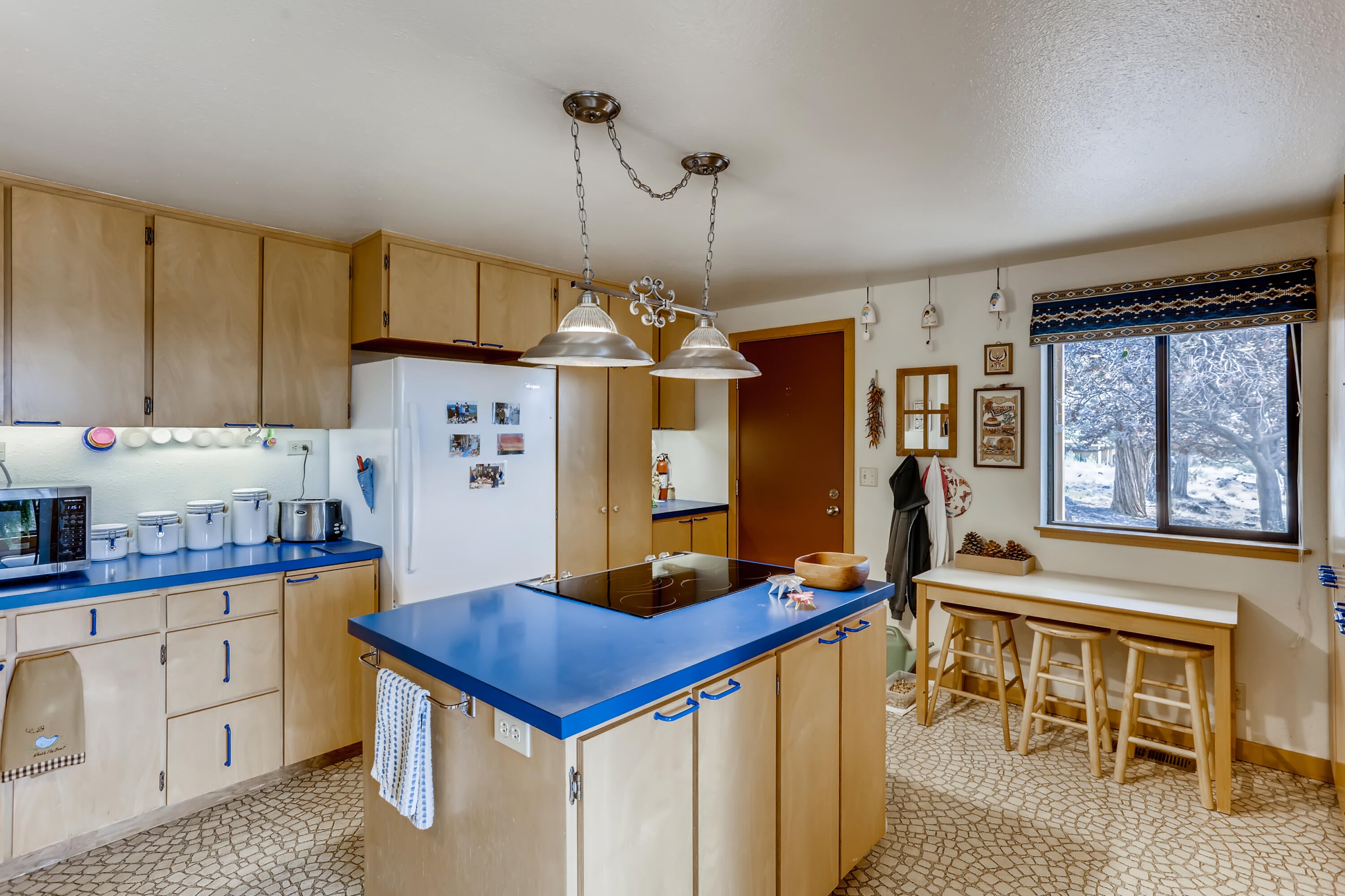 This kitchen offers so much in cabinets and storage space. The island is great for prep work and there is an eating area by the window.