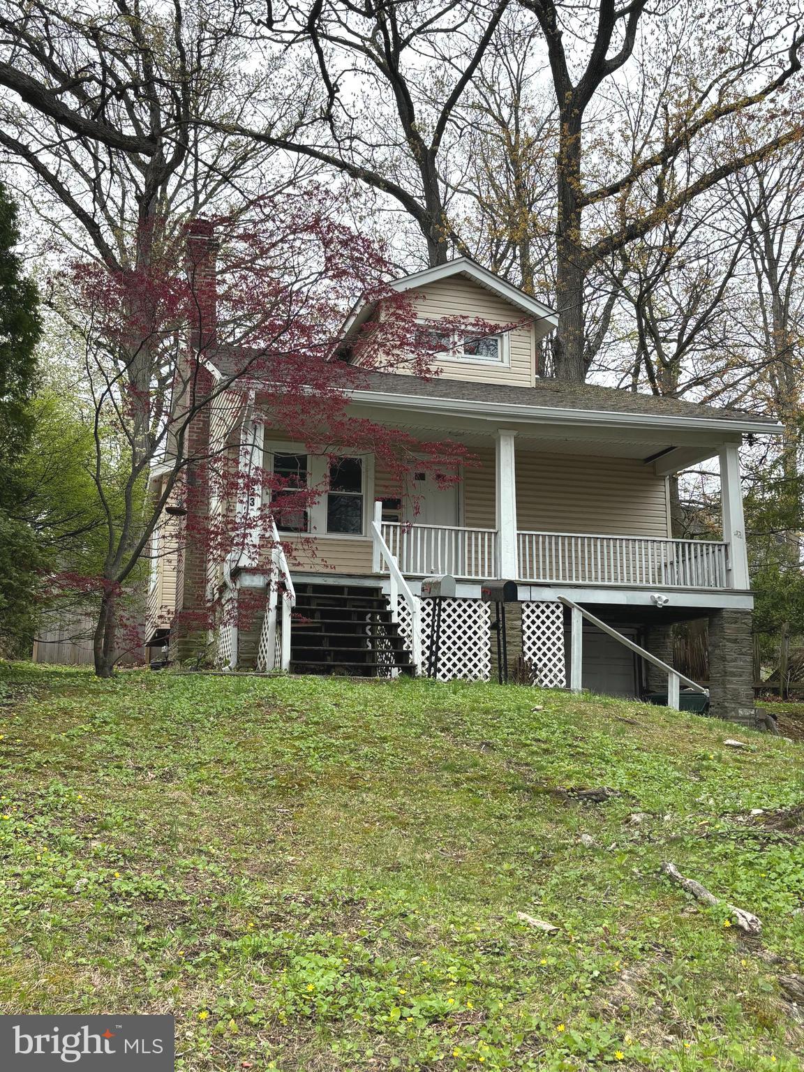 a view of a house with a big yard and large tree