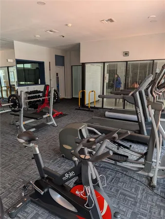 a room with gym equipment and a flat screen tv