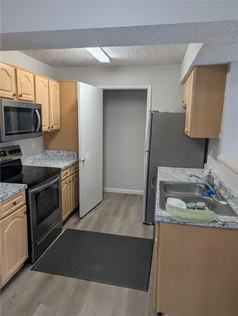 a kitchen that has a sink and a stove top oven