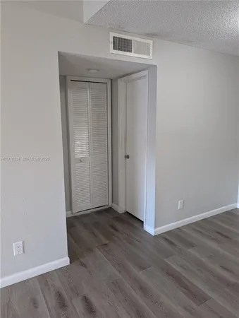 an empty room with wooden floor and closet