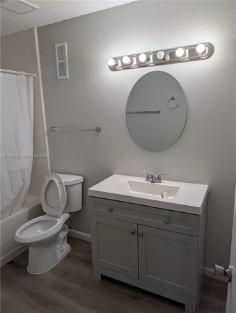a bathroom with a toilet a sink and mirror