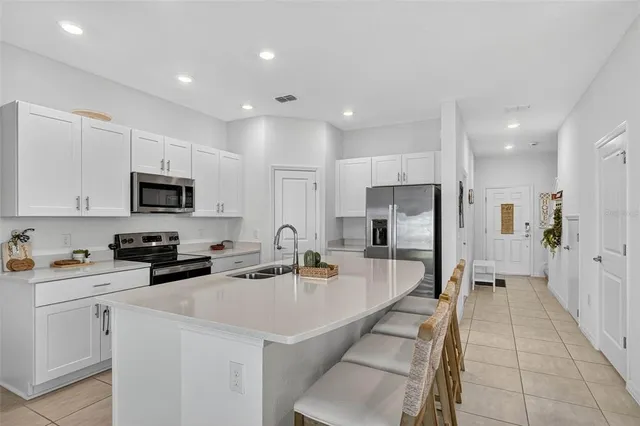 a kitchen with stainless steel appliances a sink stove refrigerator and cabinets