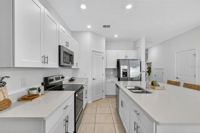 a kitchen with a table chairs a stove a microwave and cabinets