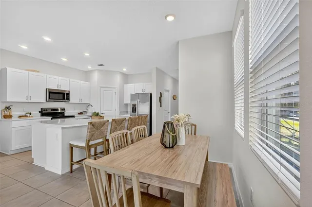 a kitchen with stainless steel appliances kitchen island granite countertop a table and chairs