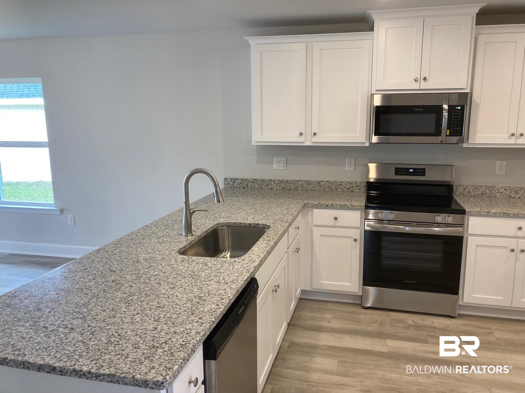 705 Mayflower Drive Foley, AL 36535 - Photo 4 of 19 Kitchen featuring a sink, white cabinets, appliances with stainless steel finishes, and a peninsula