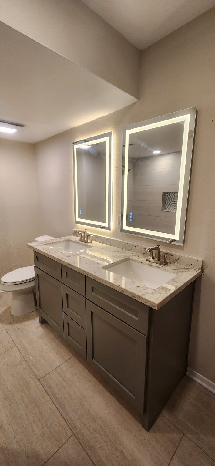 909 Silber Road, Unit 27E Houston, TX 77024 - Photo 5 of 15 a bathroom with a double vanity sink and a mirror
