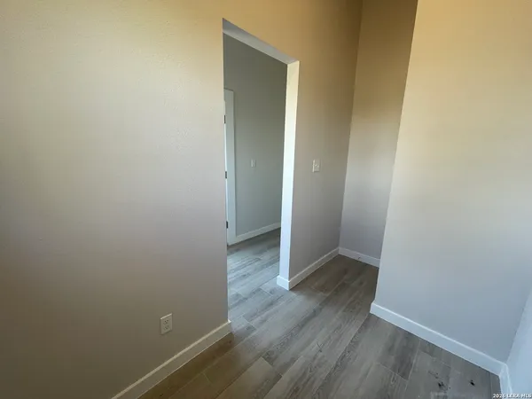 a view of an empty room with wooden floor