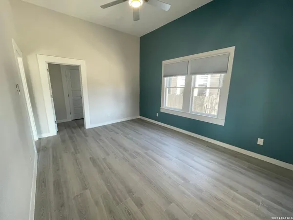 an empty room with wooden floor and windows