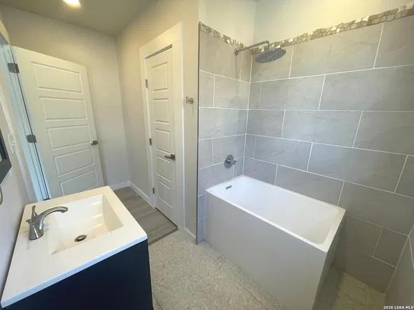 a bathroom with a tub a sink and mirror