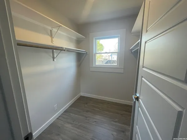 a view of a room with wooden floor and small window