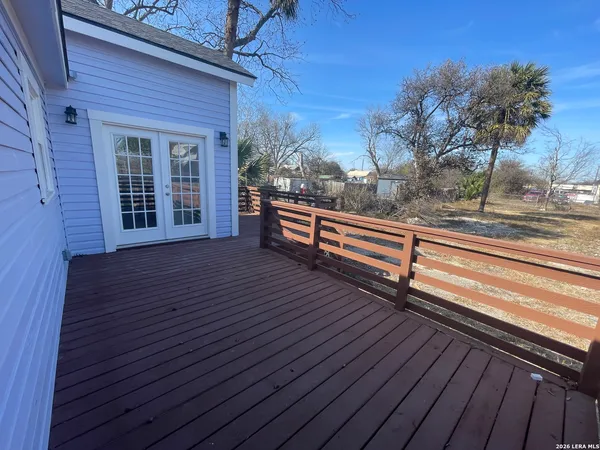 a view of a roof deck with wooden floor and fence and a floor to ceiling window