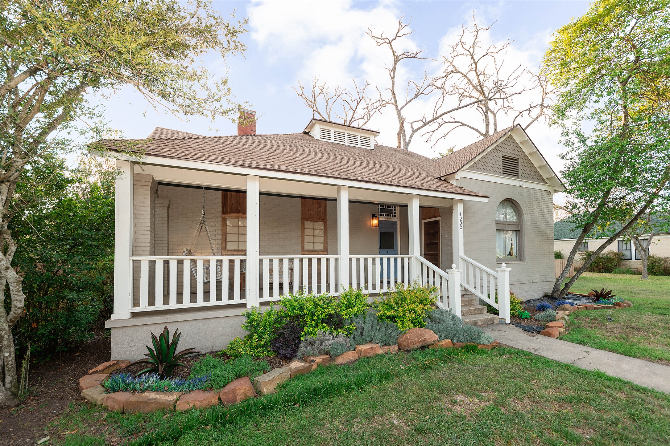 1202 Pecan Street Bastrop, TX 78602 - Photo 2 of 38 a front view of a house with a garden and plants