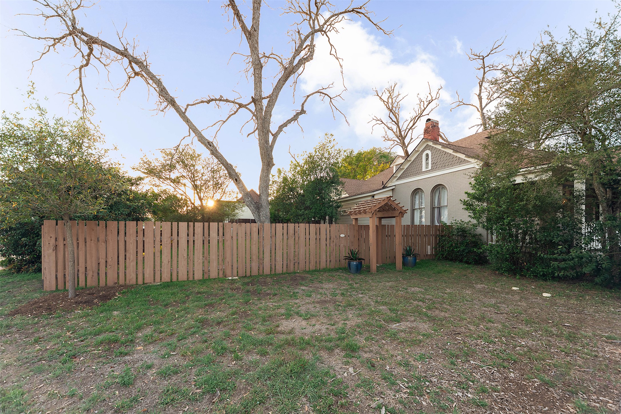 1202 Pecan Street Bastrop, TX 78602 - Photo 34 of 38 a view of a backyard with wooden fence and a bench
