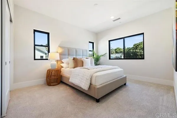 a spacious bedroom with a bed and a dresser