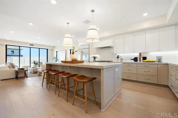 a kitchen with kitchen island granite countertop a sink cabinets and stainless steel appliances