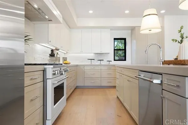 a kitchen with granite countertop a sink stainless steel appliances and cabinets