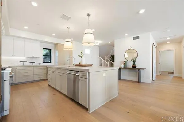 a kitchen with kitchen island a counter top space a sink stainless steel appliances and cabinets