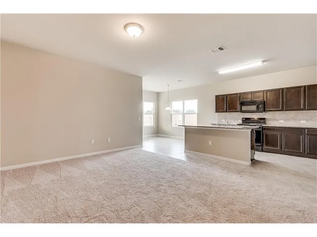a view of kitchen with microwave oven stove and cabinets